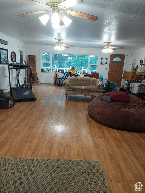 Living room with a wealth of natural light, ceiling fan, and hardwood / wood-style floors