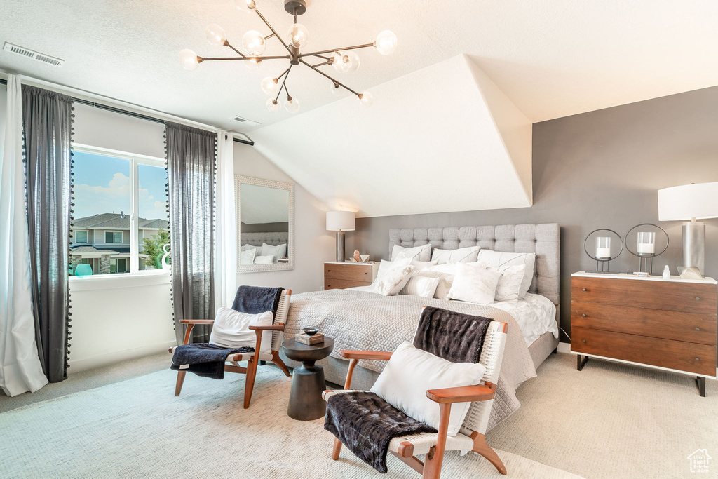 Bedroom featuring an inviting chandelier, a textured ceiling, vaulted ceiling, and light colored carpet