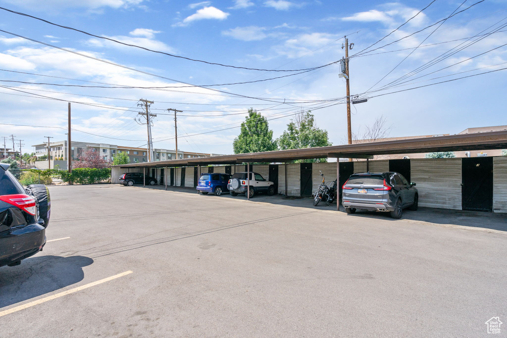 View of parking / parking lot featuring a carport