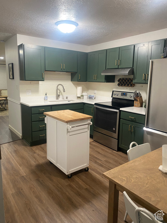 Kitchen featuring dark hardwood / wood-style flooring, green cabinets, and stainless steel appliances