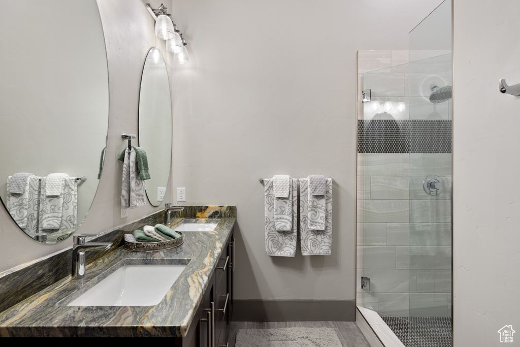Full bath with a sink, double vanity, and a stall shower