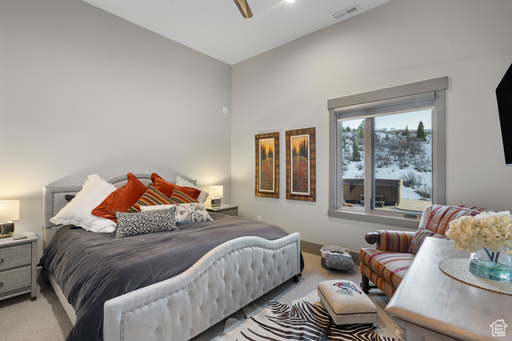 Bedroom with visible vents, light colored carpet, and a ceiling fan