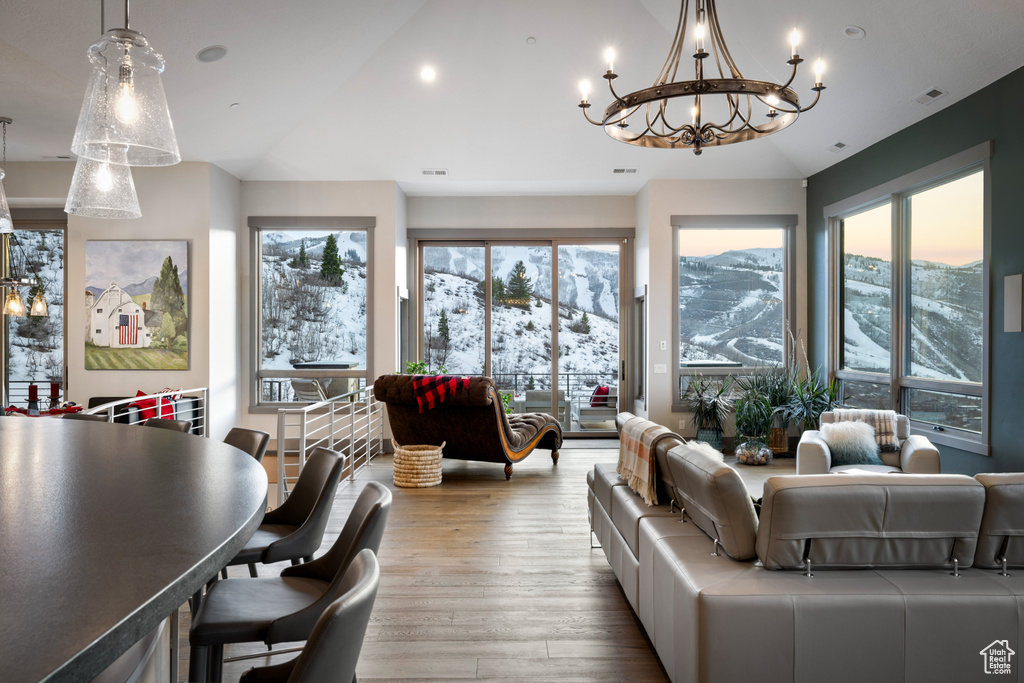 Living area featuring visible vents, a healthy amount of sunlight, wood finished floors, and vaulted ceiling