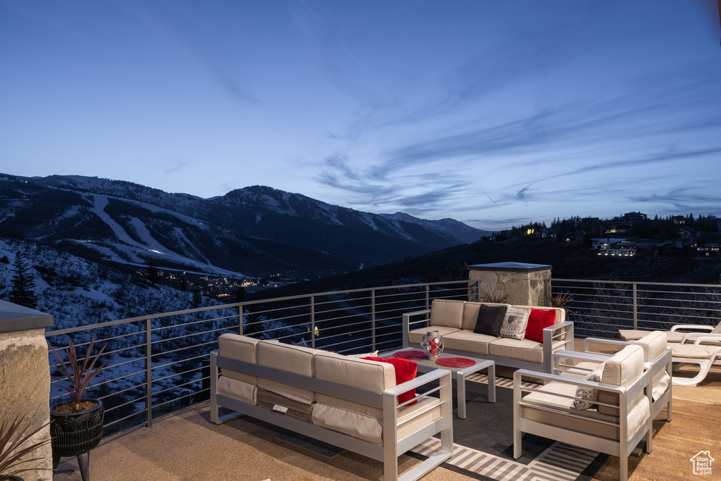 View of patio with an outdoor living space, a mountain view, and a balcony