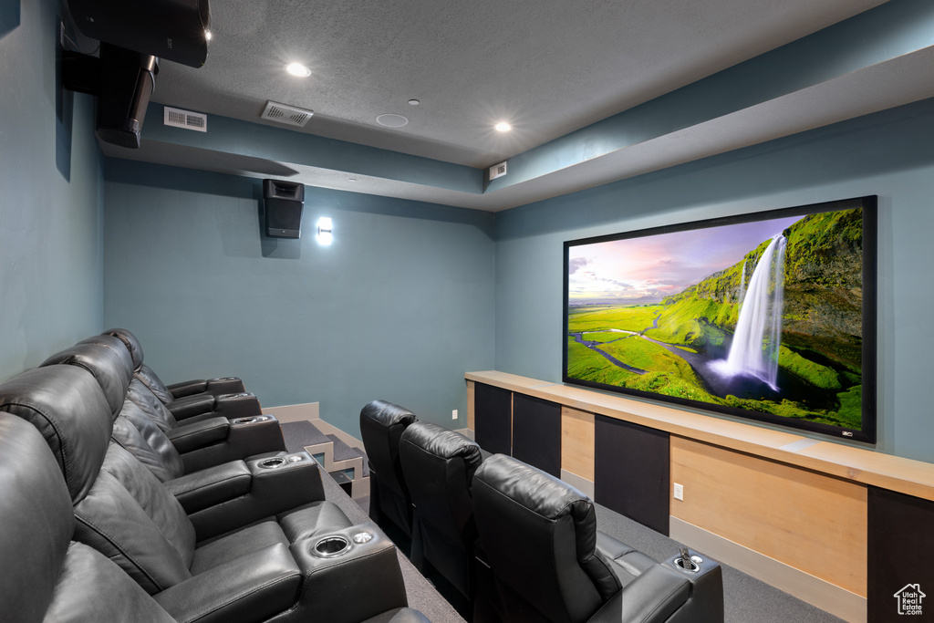 Carpeted cinema with visible vents and recessed lighting