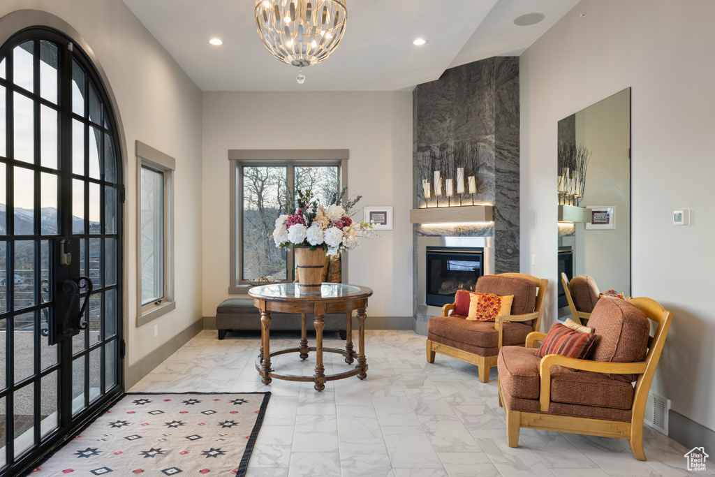 Living area featuring recessed lighting, a tiled fireplace, marble finish floor, and a chandelier