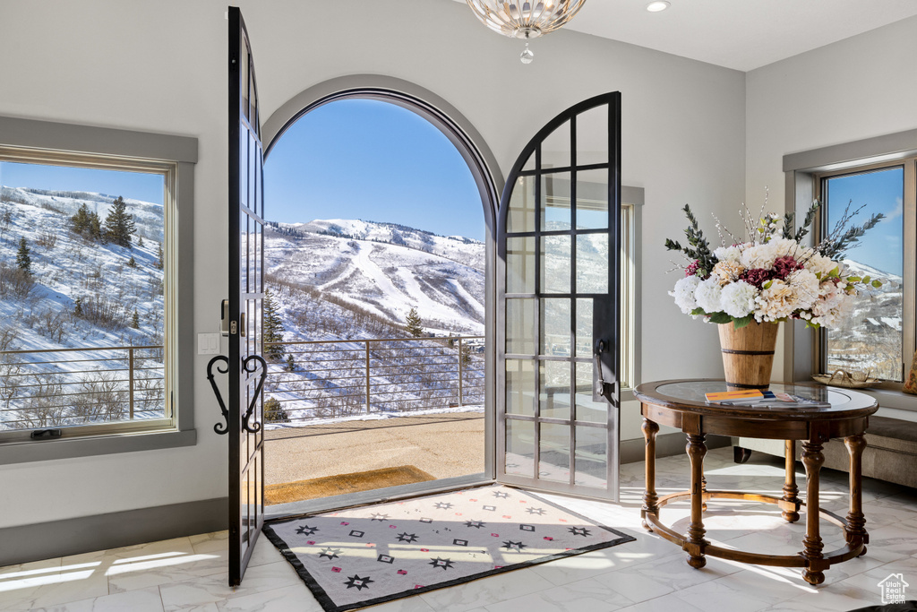 Entryway featuring a mountain view, marble finish floor, and a wealth of natural light