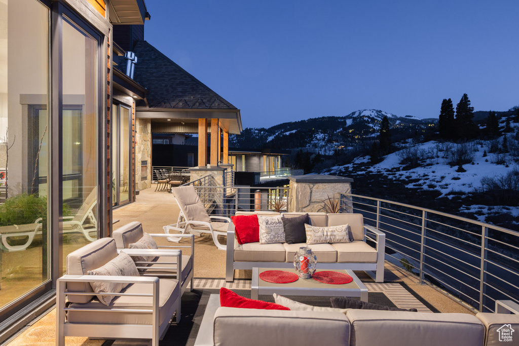 Snow covered back of property featuring outdoor lounge area and a mountain view