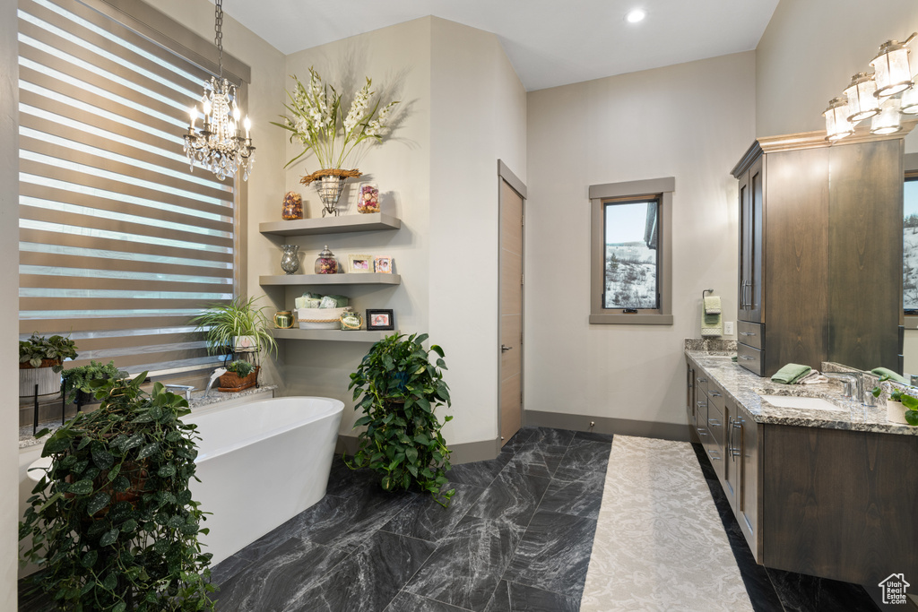 Bathroom with a freestanding tub, vanity, a chandelier, recessed lighting, and marble finish floor