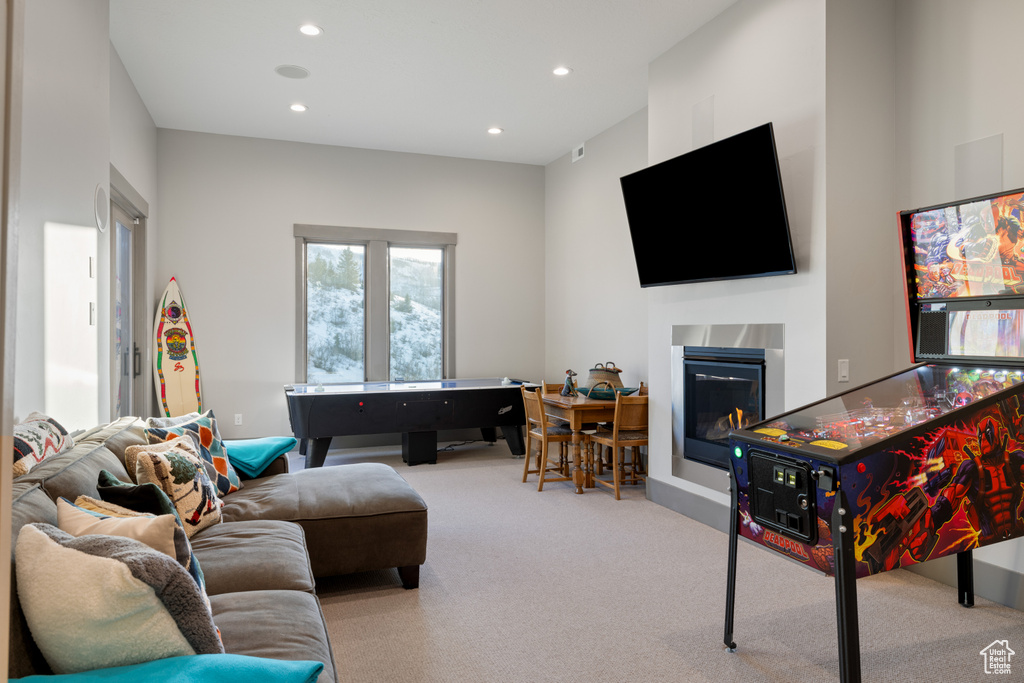 Game room with a glass covered fireplace, recessed lighting, and carpet flooring