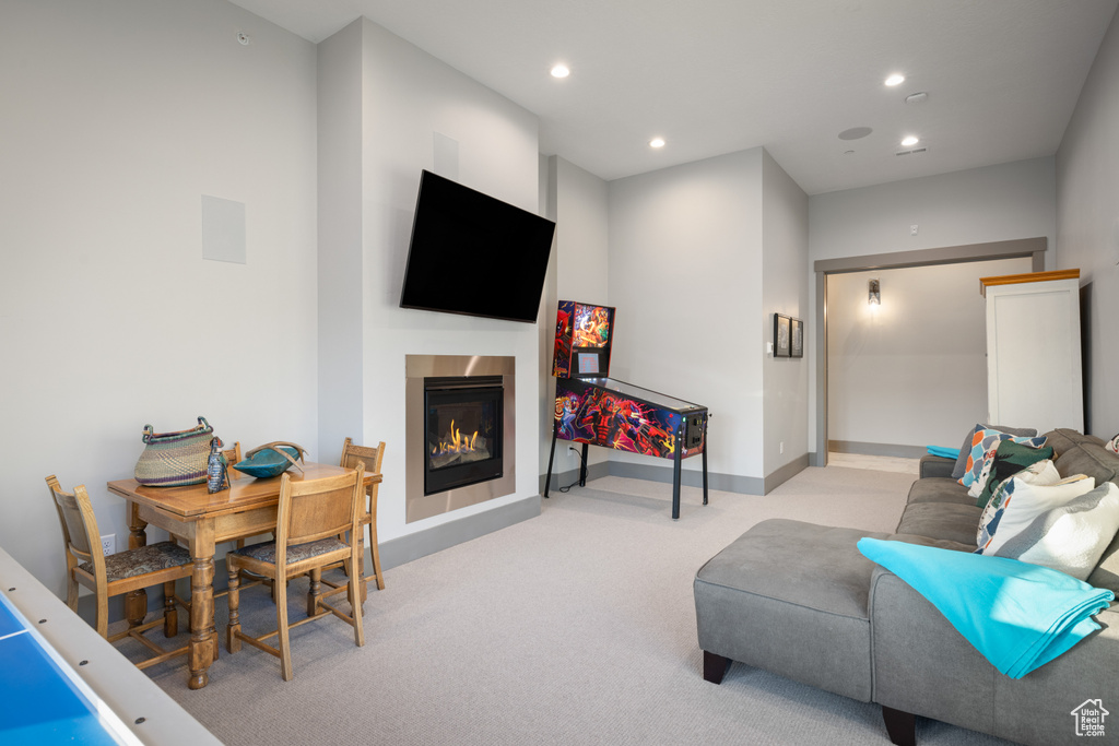 Carpeted living area with a glass covered fireplace, recessed lighting, and baseboards