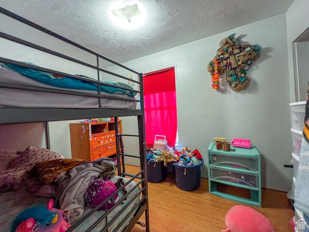 Bedroom featuring a textured ceiling and light hardwood / wood-style flooring