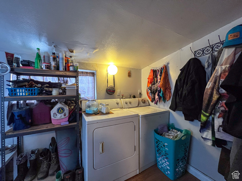 Clothes washing area with separate washer and dryer and a textured ceiling