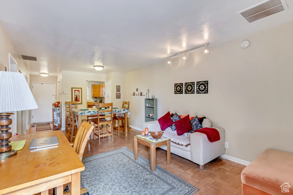 Living room featuring track lighting and light parquet flooring