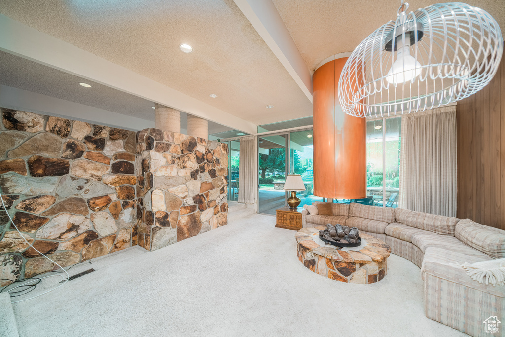 Living room featuring a textured ceiling, carpet, and plenty of natural light
