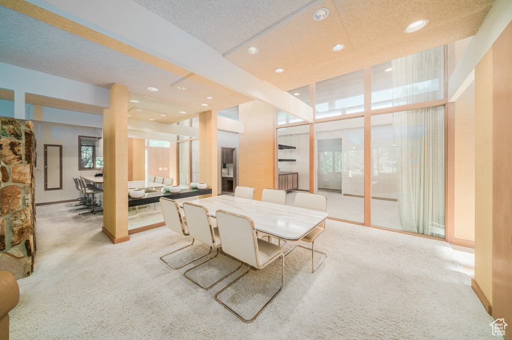 Carpeted dining area featuring a textured ceiling