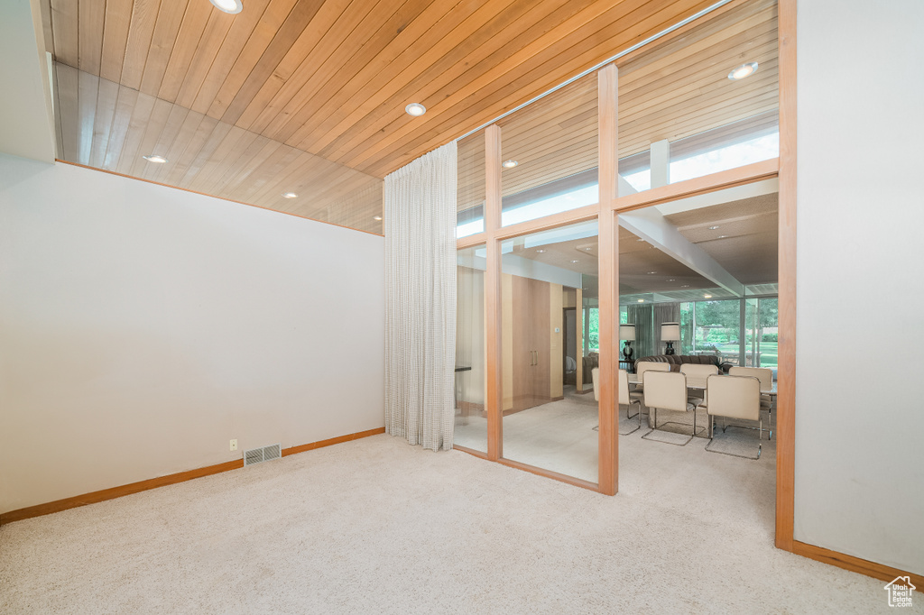 Interior space with wood ceiling and light carpet