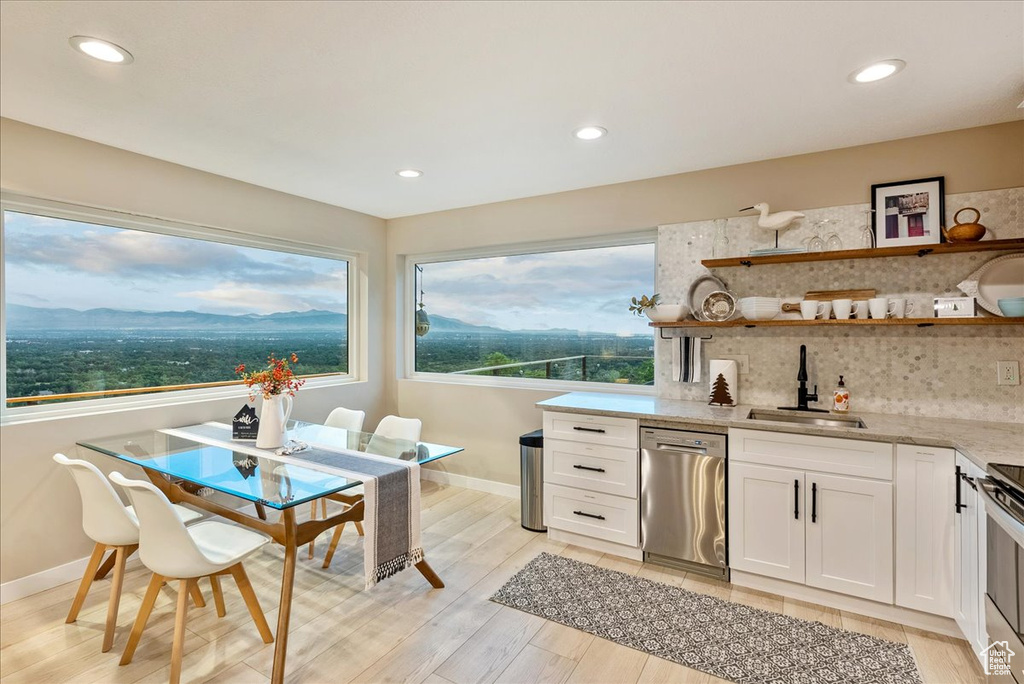 Kitchen featuring sink, appliances with stainless steel finishes, backsplash, and white cabinetry