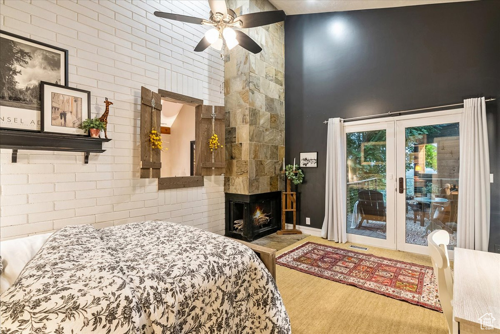 Bedroom with french doors, access to outside, ceiling fan, wood-type flooring, and a multi sided fireplace