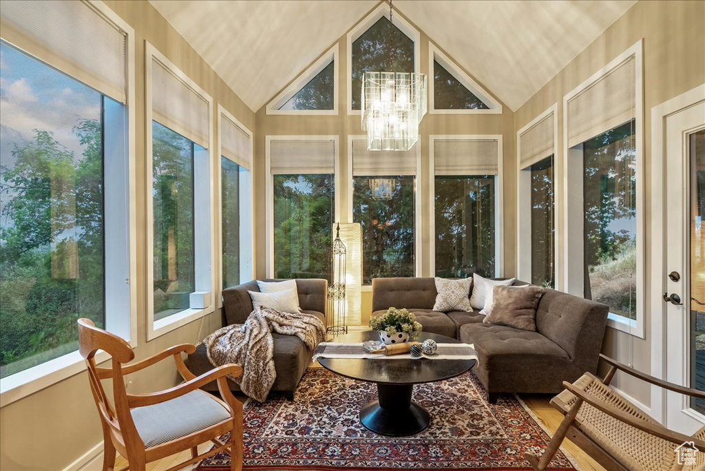 Sunroom with vaulted ceiling and an inviting chandelier