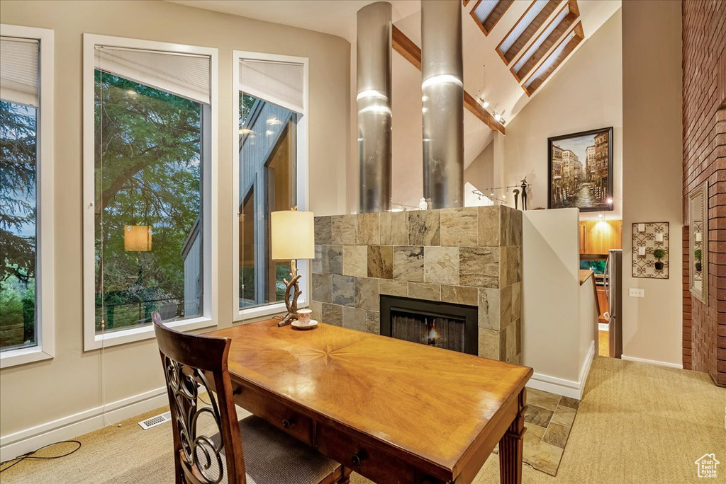 Dining area with a fireplace, lofted ceiling, and carpet