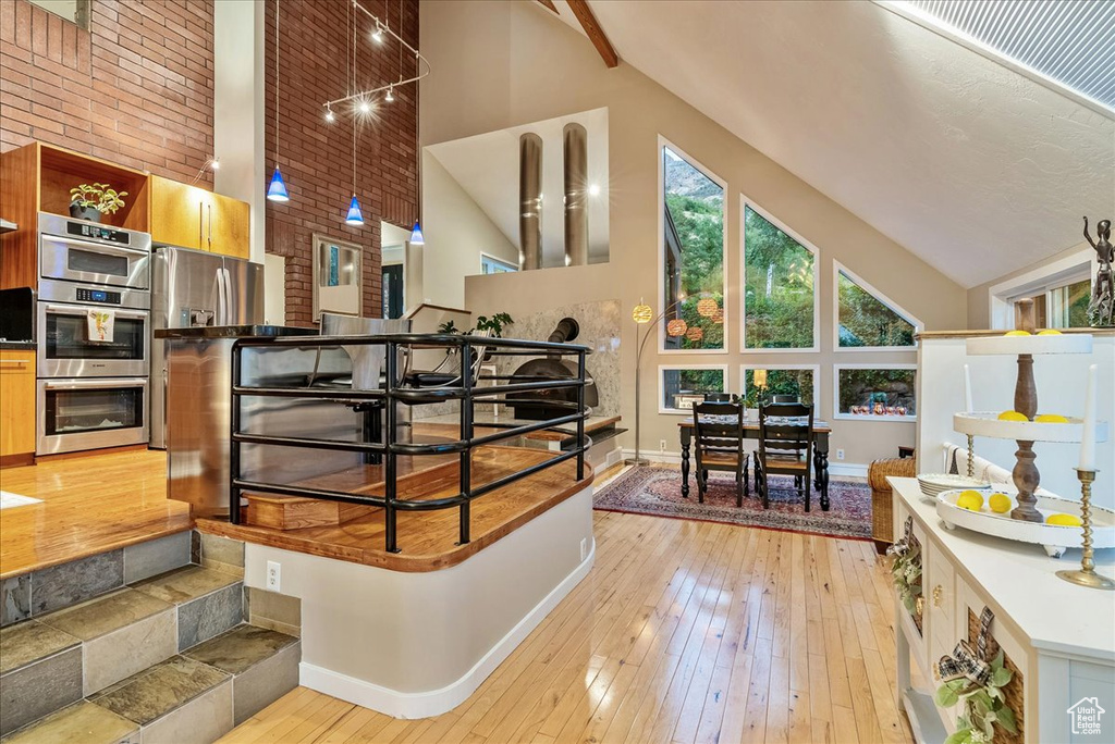 Interior space featuring beamed ceiling, light wood-type flooring, and high vaulted ceiling