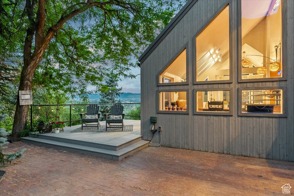 Property exterior at dusk featuring a wooden deck