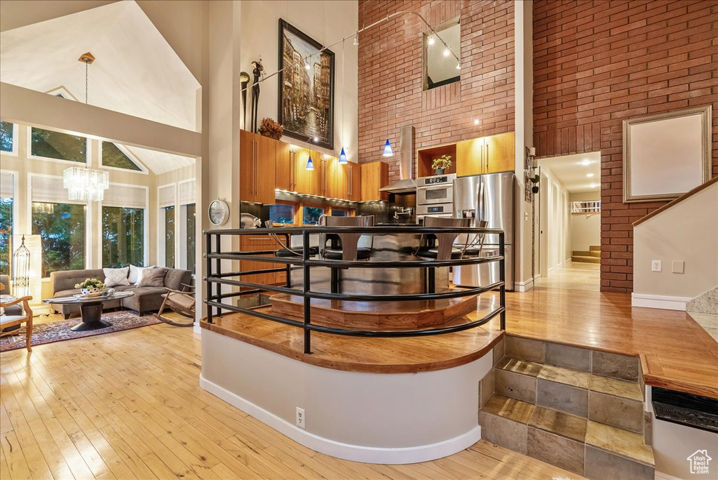 Interior space with light hardwood / wood-style floors, an inviting chandelier, and a high ceiling