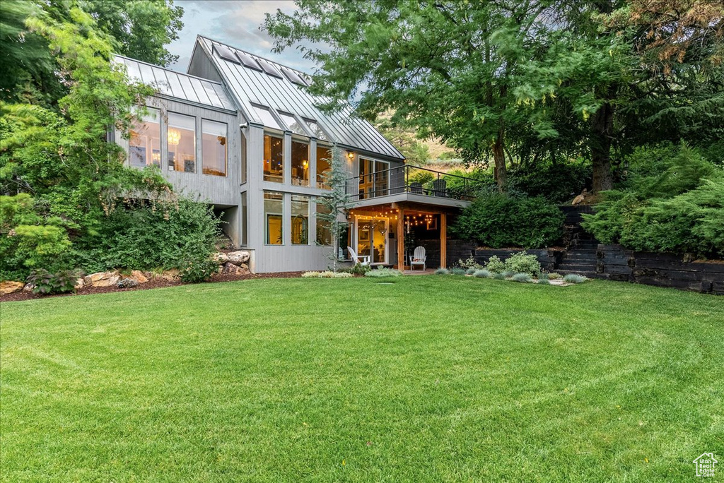 Rear view of house featuring a yard