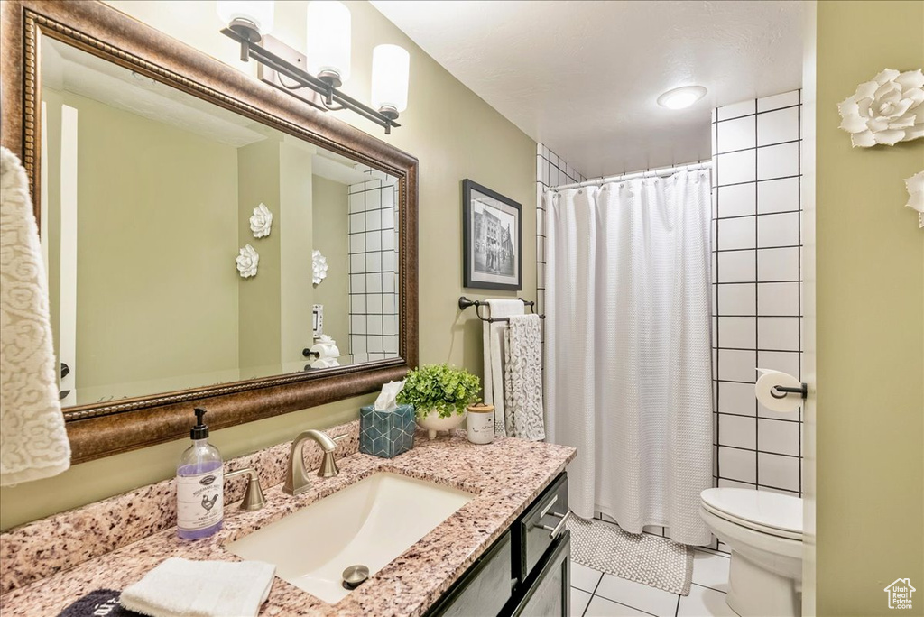 Bathroom featuring tile patterned flooring, toilet, and vanity