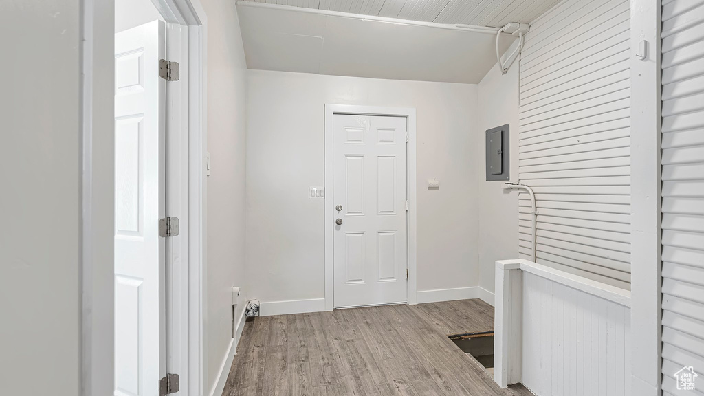 Hall with light hardwood / wood-style floors and electric panel