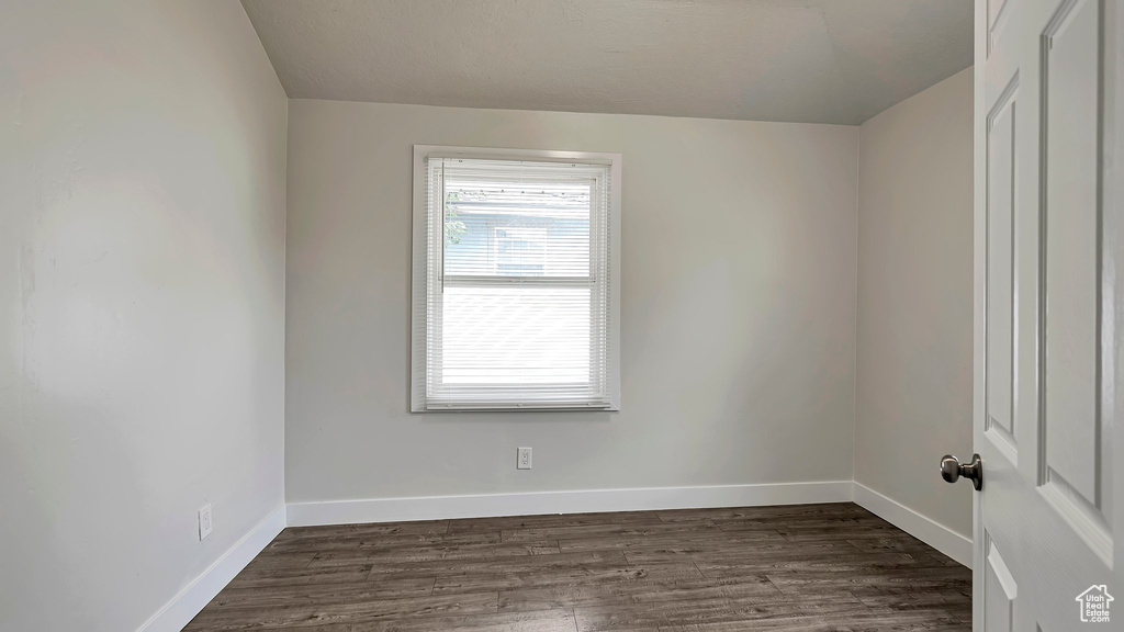 Empty room with dark hardwood / wood-style flooring