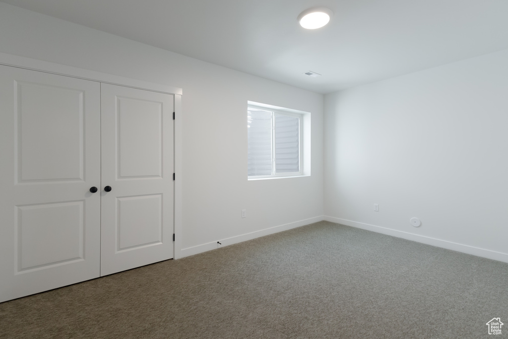 Unfurnished bedroom with a closet and carpet flooring