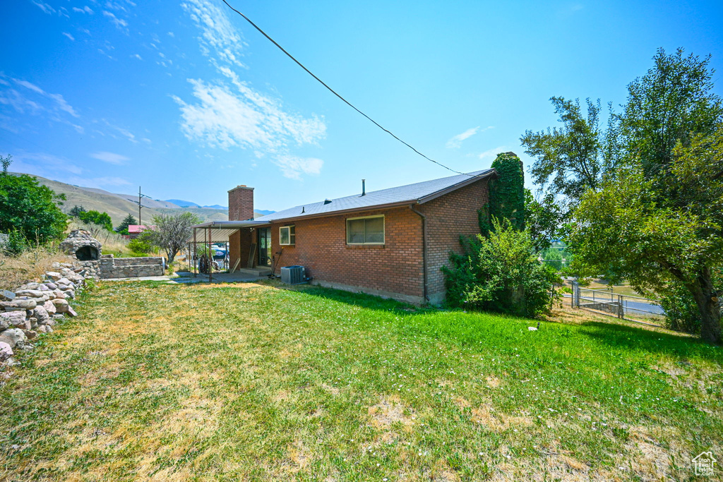 View of yard with a mountain view and central AC unit