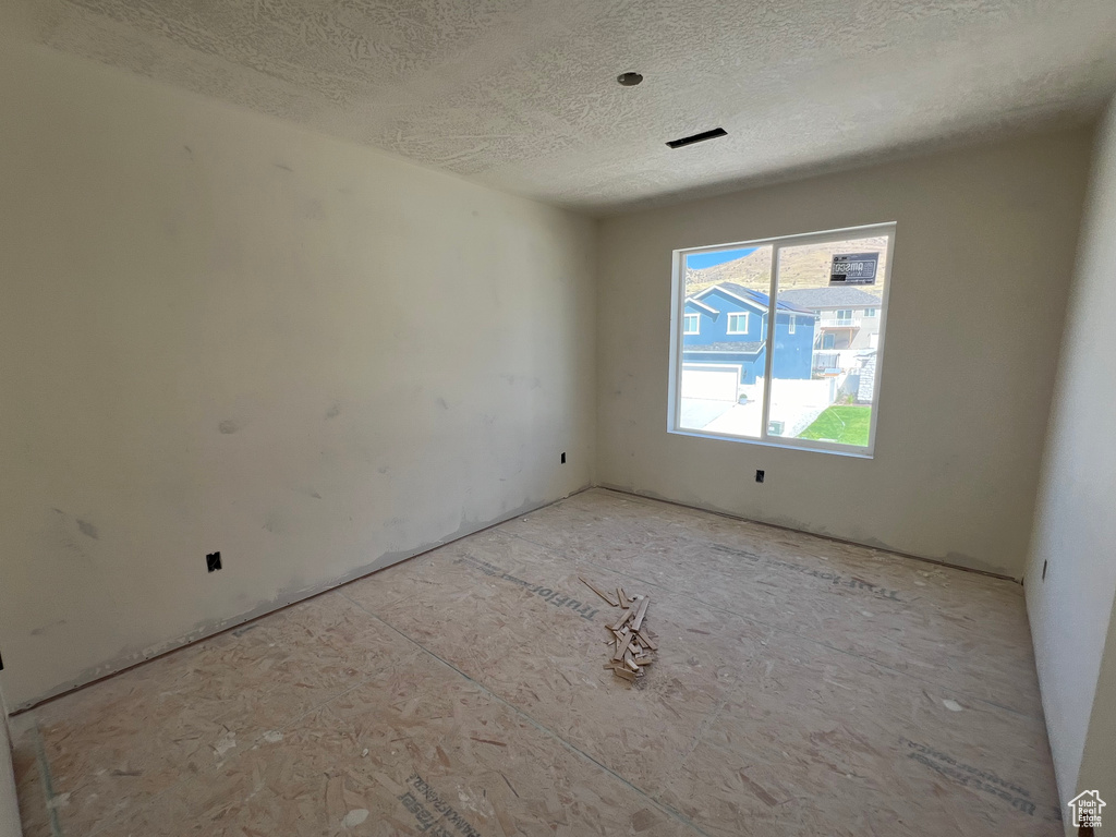 Empty room featuring a textured ceiling