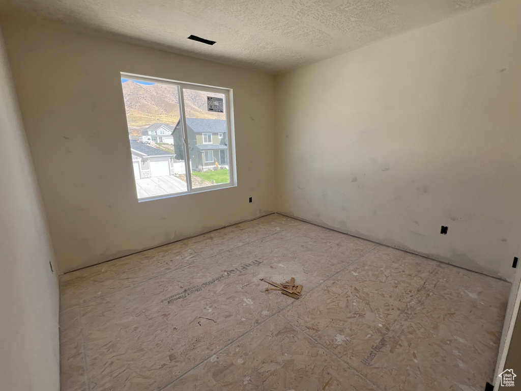 Unfurnished room featuring a textured ceiling