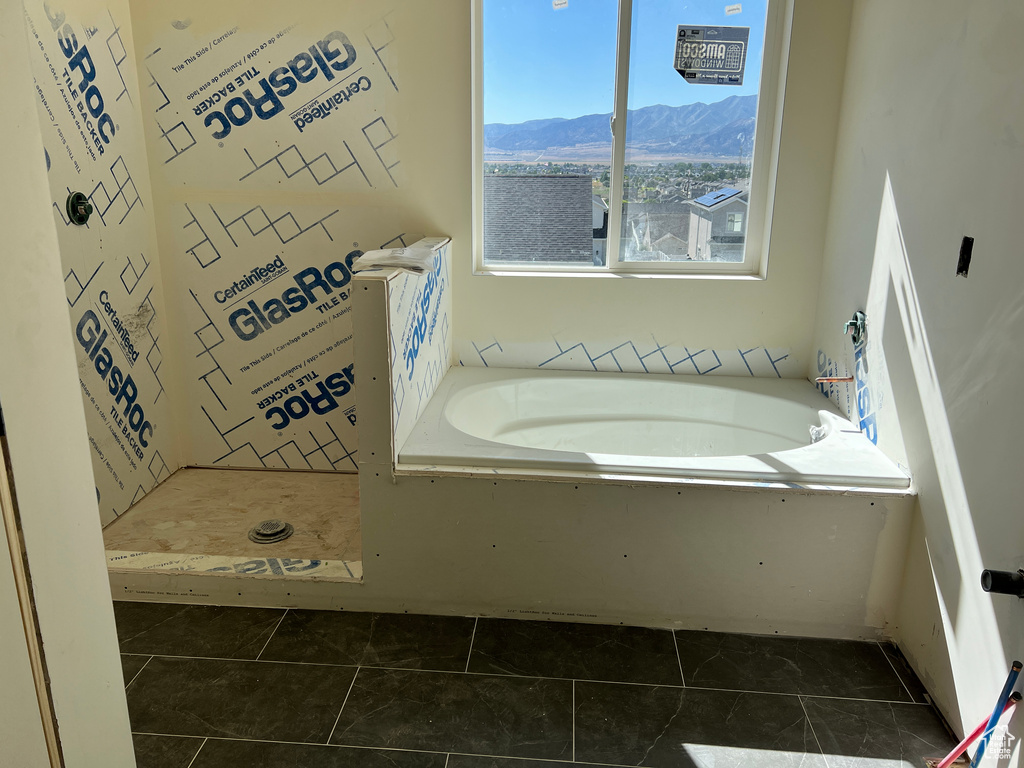 Bathroom featuring tile patterned flooring, a tub, and a mountain view