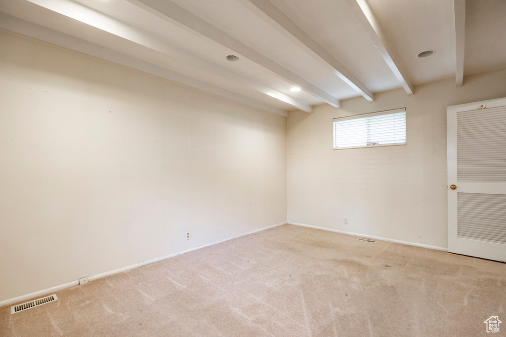 Unfurnished room featuring beamed ceiling and carpet floors