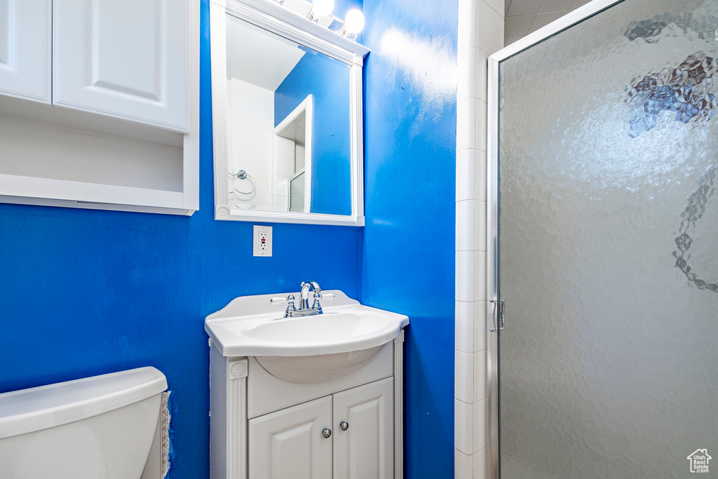 Bathroom with a shower with door, toilet, and vanity