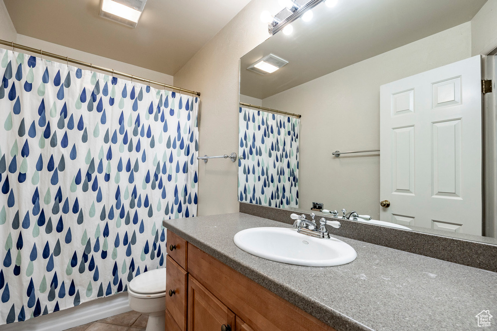 Bathroom featuring tile patterned floors, toilet, and vanity