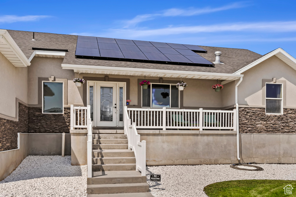 View of front of home featuring a porch and solar panels