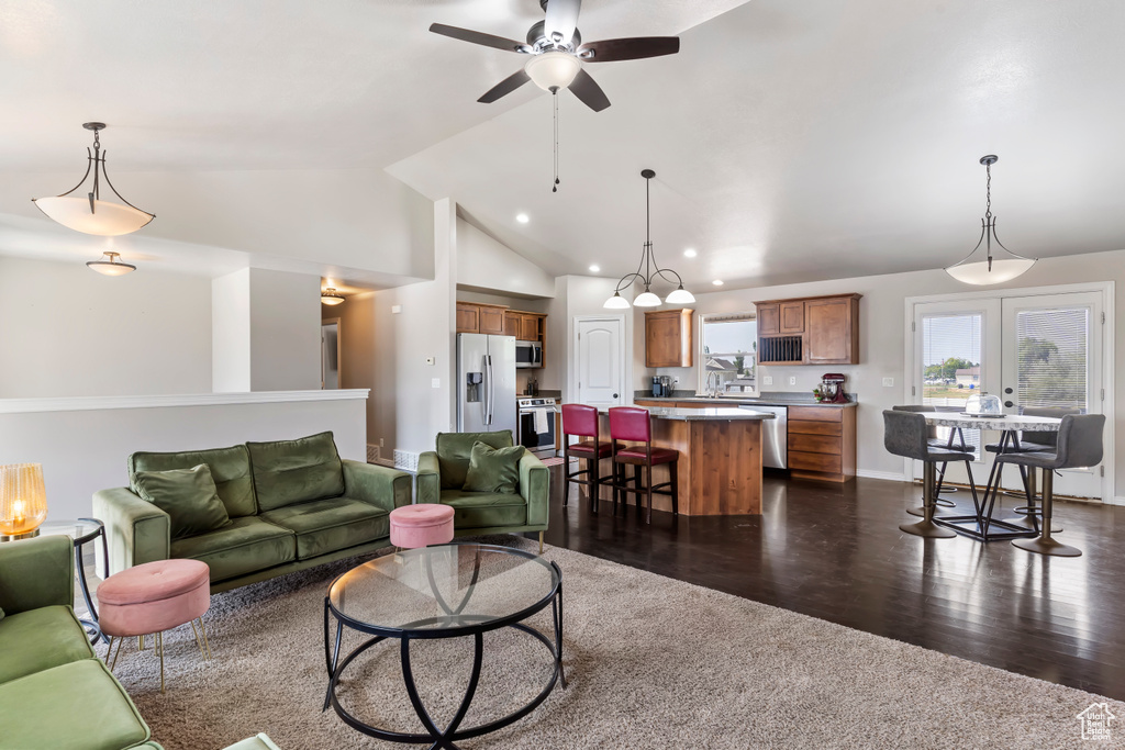 Living room with ceiling fan, french doors, dark hardwood / wood-style flooring, and lofted ceiling