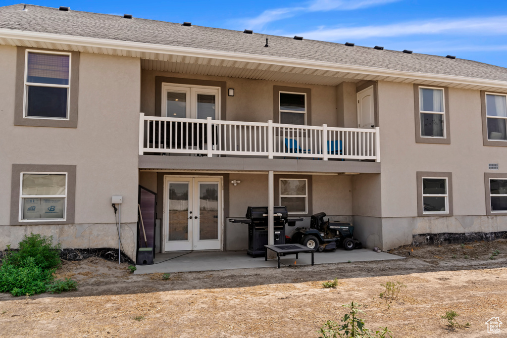 Back of house with a patio, a balcony, and french doors