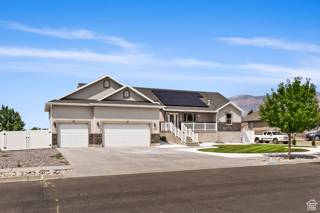 View of front of property featuring solar panels, a mountain view, and a garage