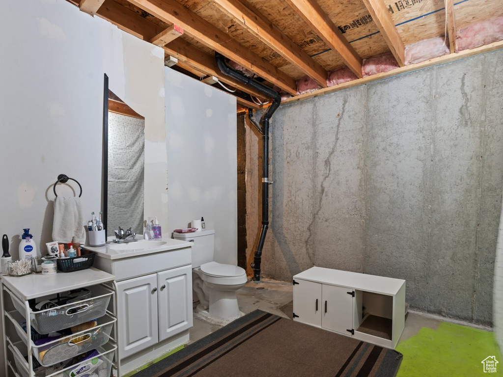 Bathroom with vanity, toilet, and concrete floors