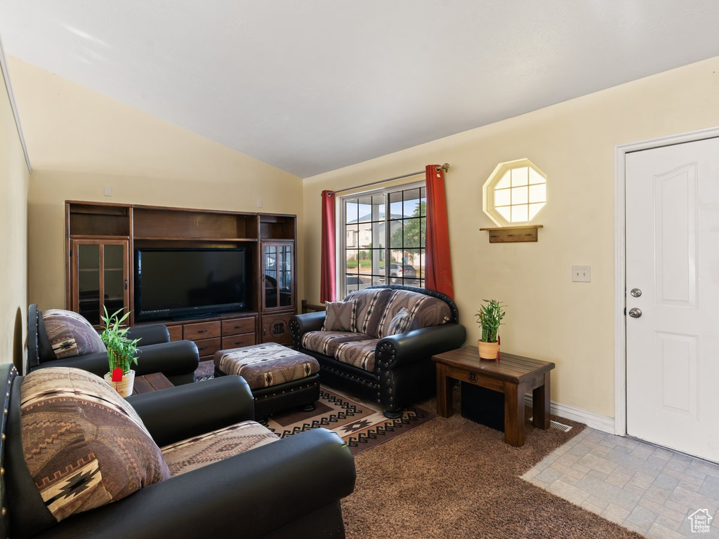 Living room featuring carpet and vaulted ceiling