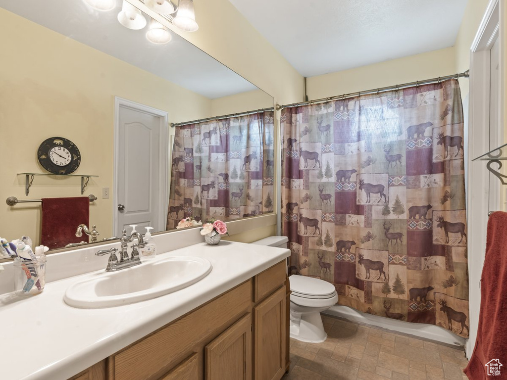 Bathroom featuring tile patterned floors, toilet, and vanity