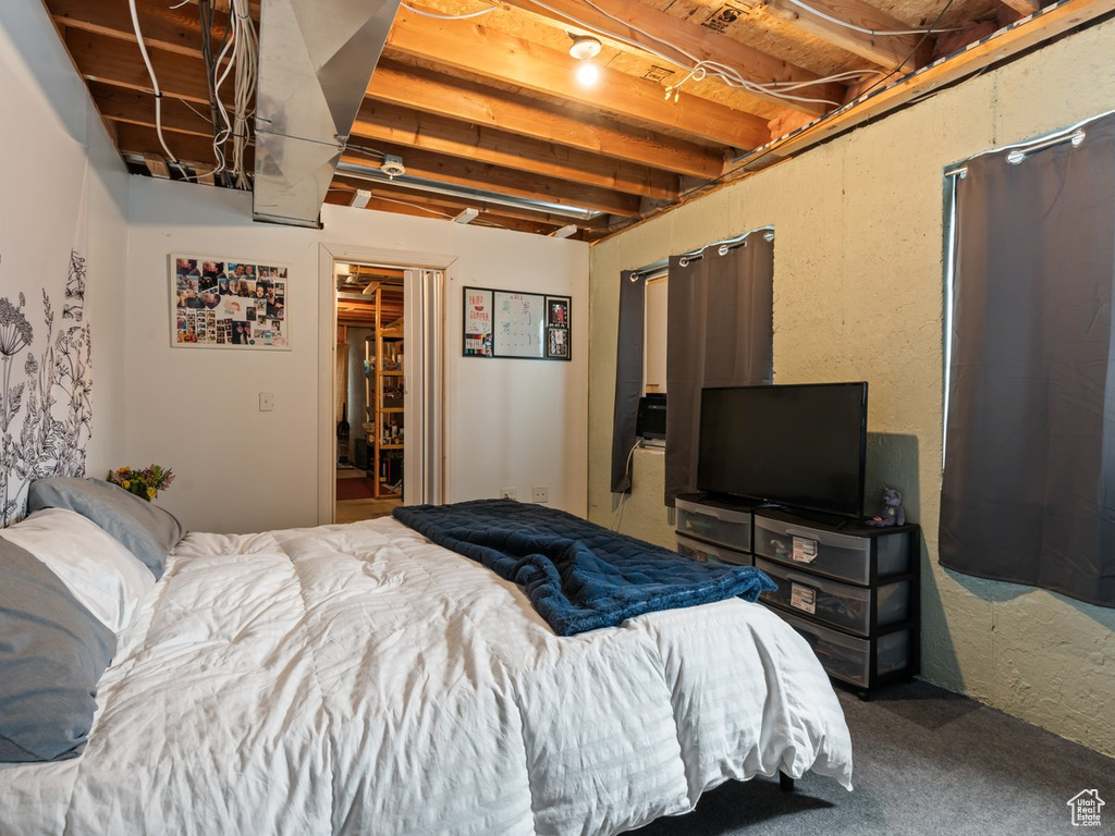 Bedroom with carpet floors and beam ceiling