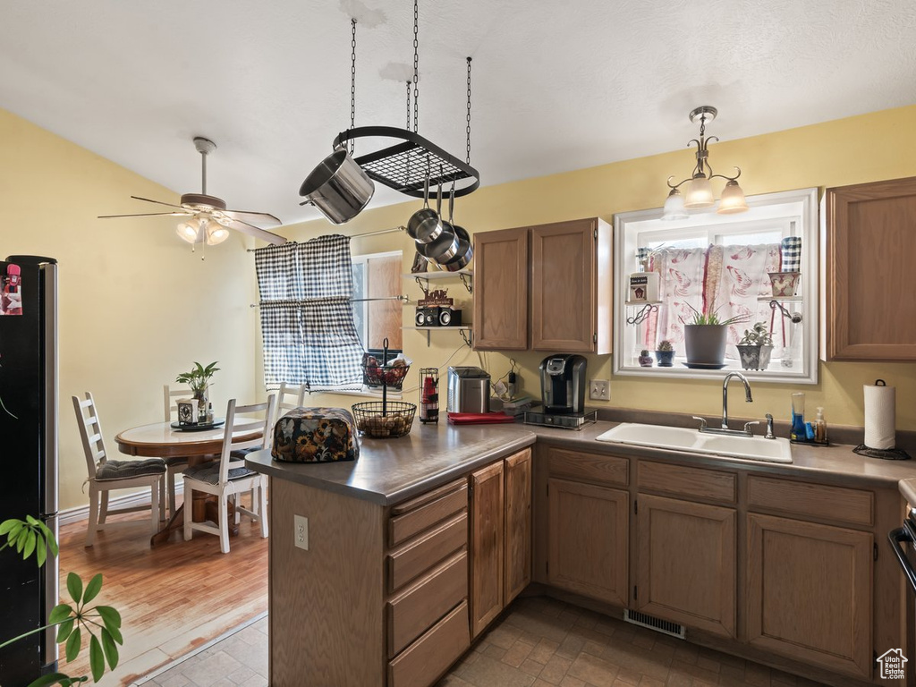 Kitchen with sink, light wood-type flooring, stainless steel fridge, and a healthy amount of sunlight