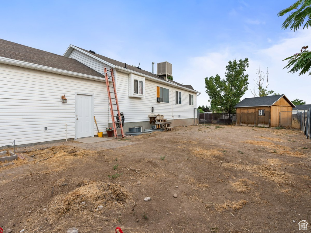 Rear view of house featuring a storage unit